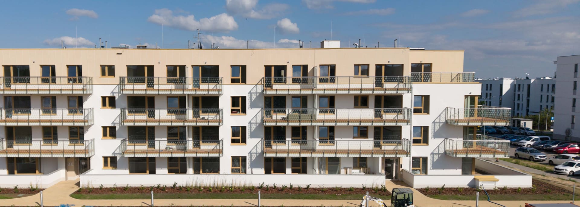 Elewacja ukończonego budynku Nova Daliova — balkony ze szklanymi balustradami w autorski wzór kwiatowy